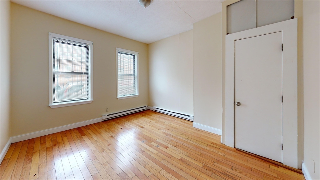 249 Washington Street, Unit 1 Boston, MA 02121 - Photo 4 of 8 a view of an empty room with wooden floor and a window