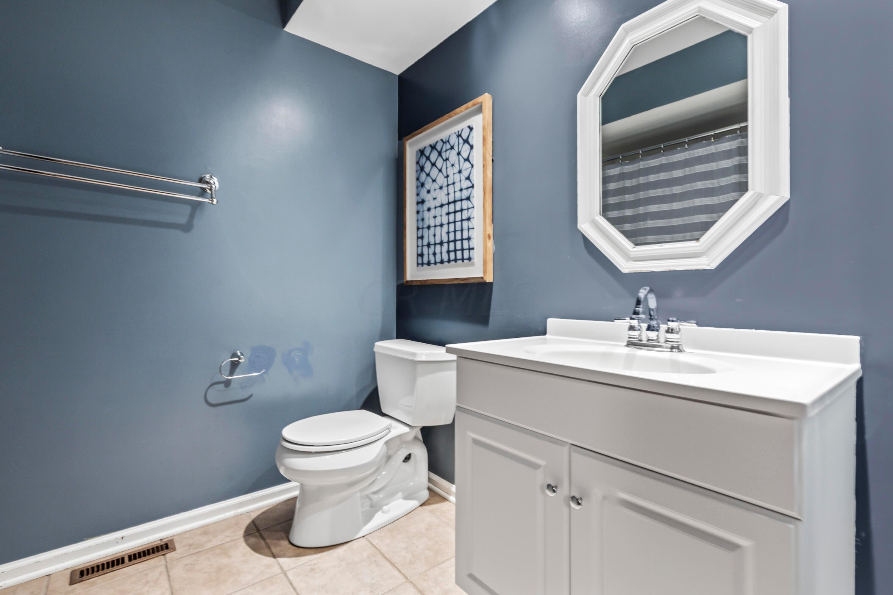 7020 Rieber Street Columbus, OH 43085 - Photo 34 of 40 • New ceramic tile flooring ~ 2017 • Blue painted walls • Tub/shower combination with ceramic tile surround • Enclosed vanity with single bowl, cultured marble sinktop • Mirrored medicine cabinet • Can lighting • Ceiling exhaust
