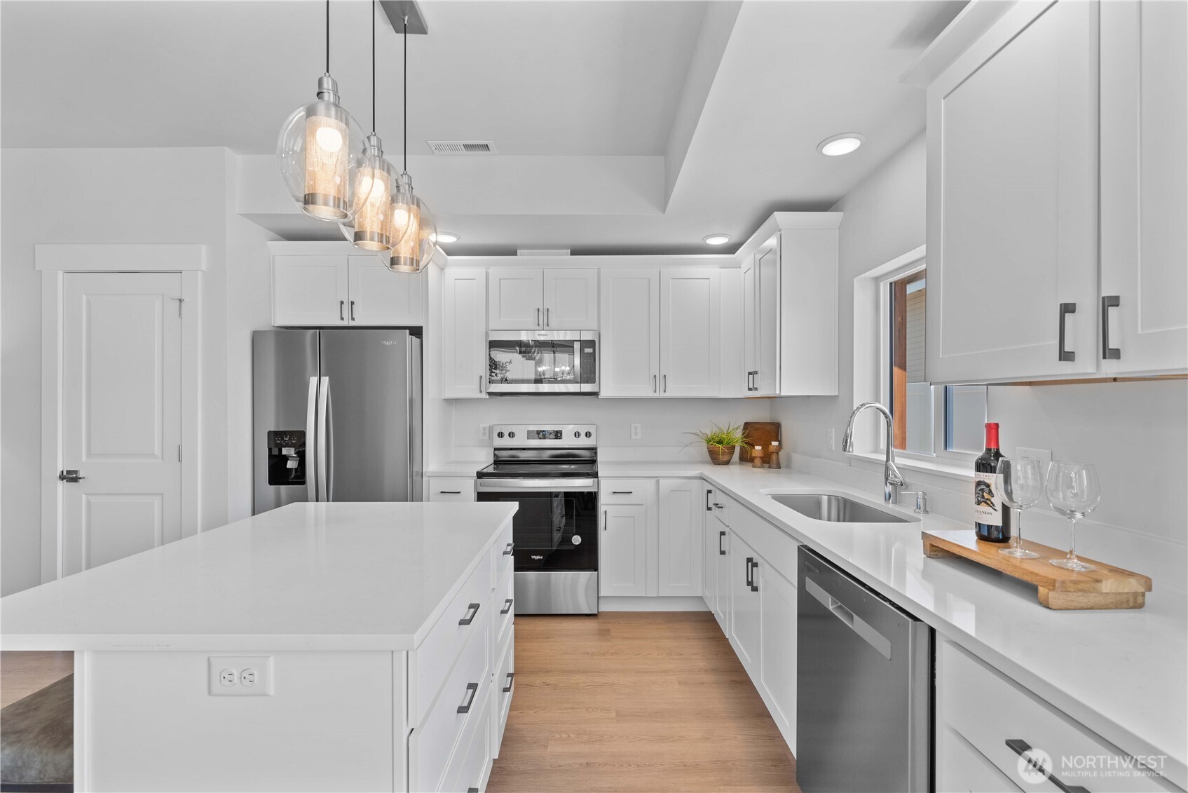 1030 Finch Lane, Unit H1 Wenatchee, WA 98801 - Photo 12 of 30 a kitchen with kitchen island white cabinets and refrigerator