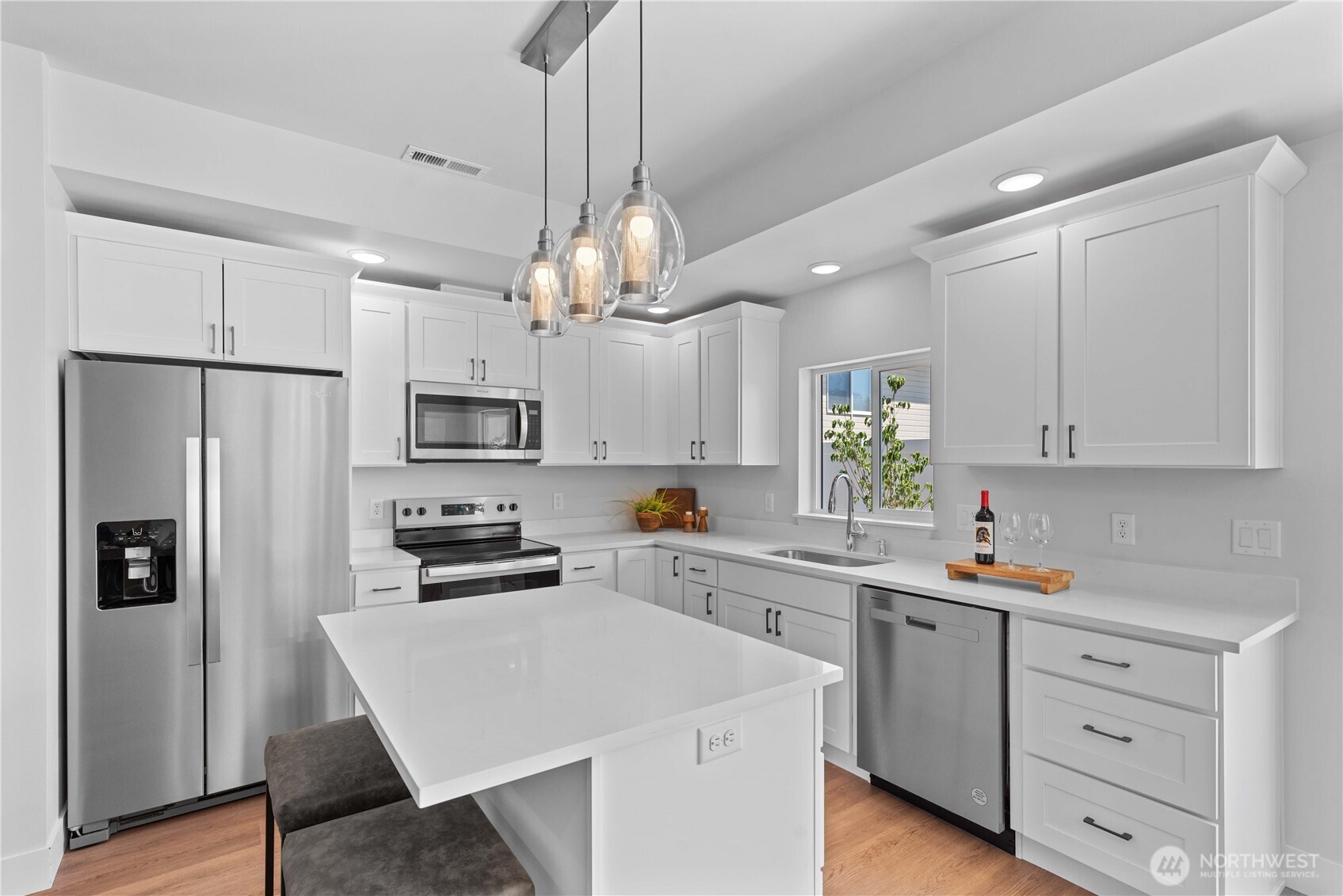 1030 Finch Lane, Unit H1 Wenatchee, WA 98801 - Photo 14 of 30 a kitchen with white cabinets stainless steel appliances and wooden floor