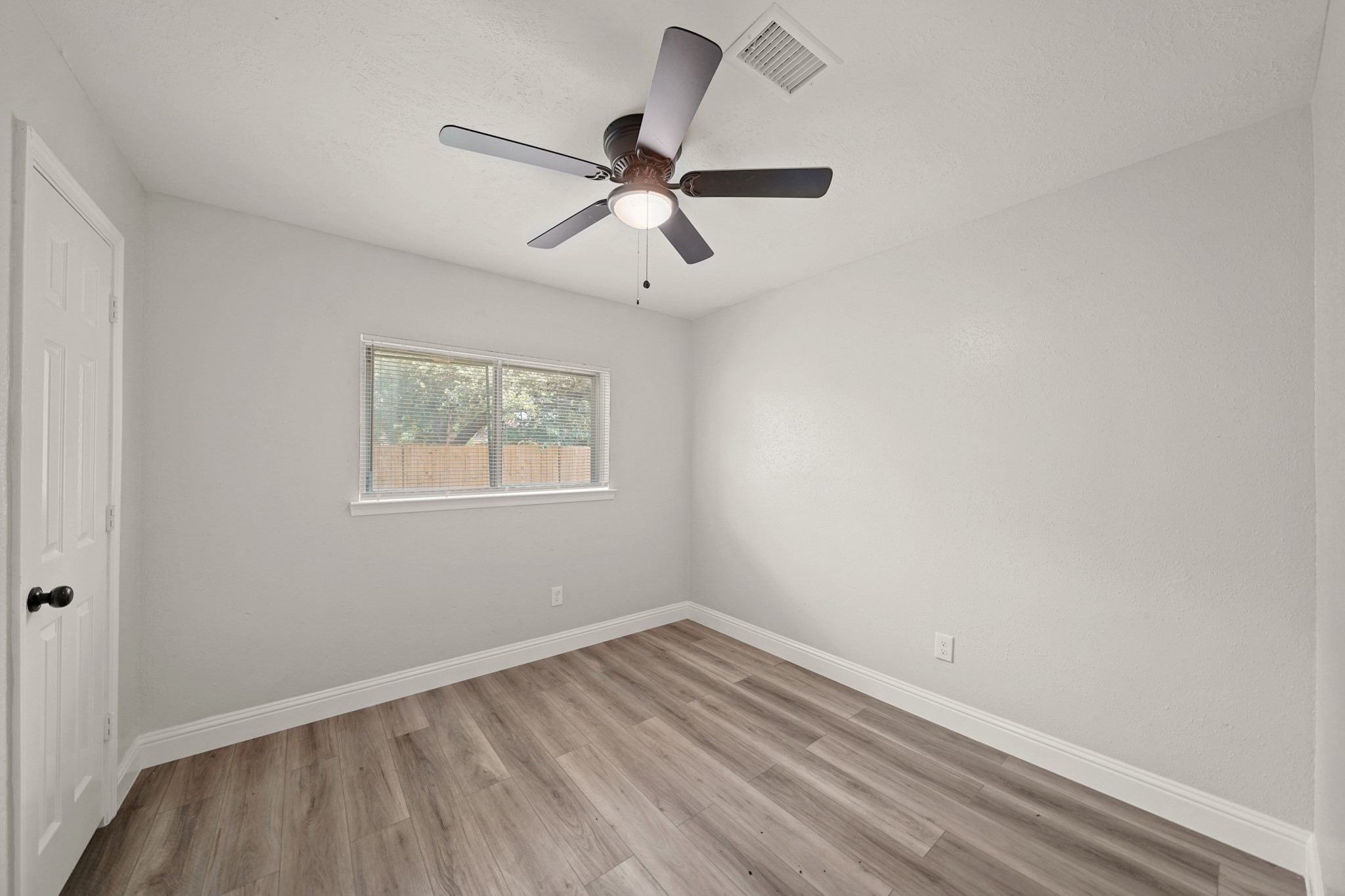 3623 Peachstone Place Spring, TX 77389 - Photo 14 of 20 an empty room with wooden floor ceiling fan and windows