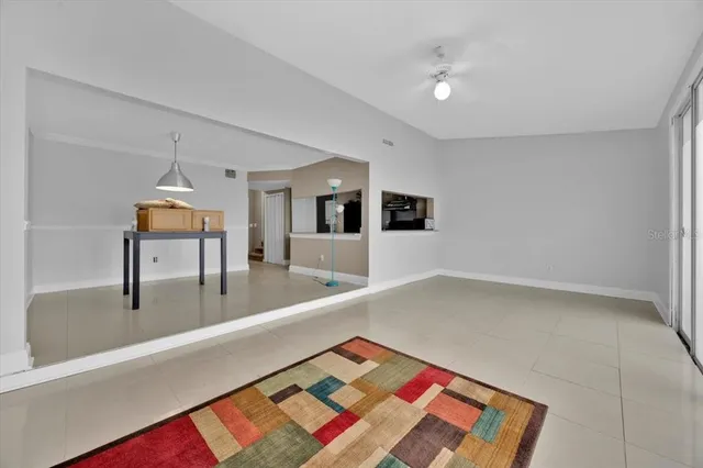 a living room with a rug and next to a window