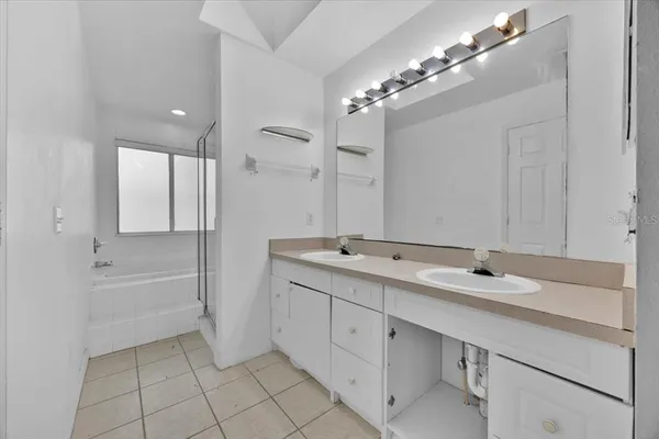 a bathroom with a tub sink and mirror
