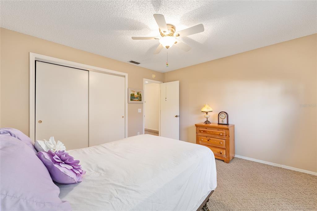 1710 Rosales Road The Villages, FL 32162 - Photo 15 of 23 a bedroom with a bed and a chandelier