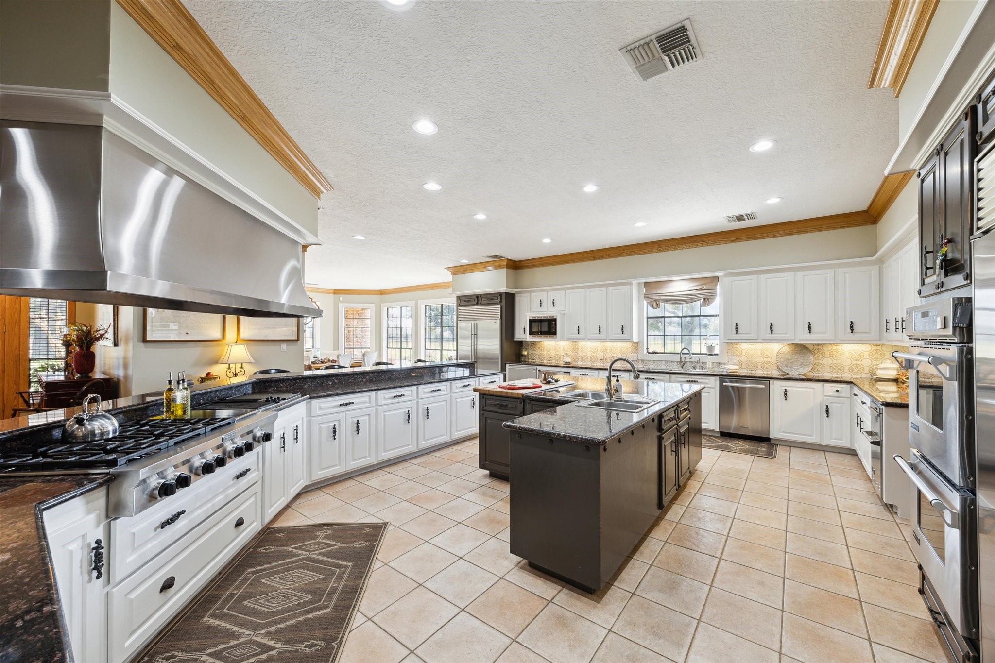 1224 Haines Road Sheridan, TX 77475 - Photo 17 of 49 a large white kitchen with stainless steel appliances lots of counter space and breakfast area
