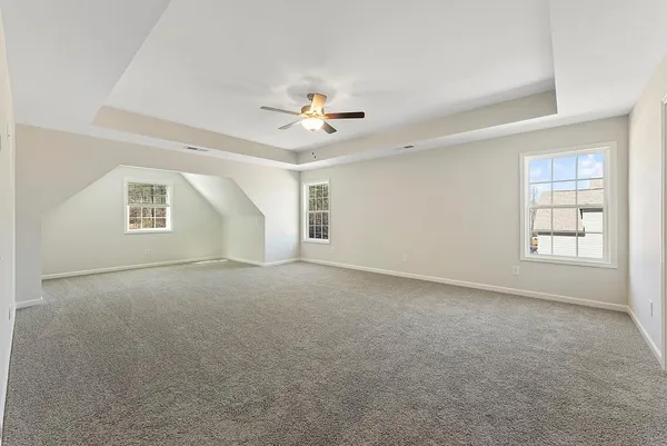 an empty room with windows and ceiling fan