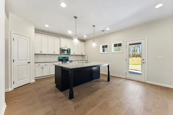 a kitchen with kitchen island granite countertop wooden cabinets and white appliances
