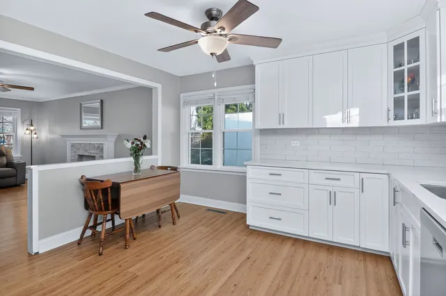 a kitchen with stainless steel appliances granite countertop a white cabinets and wooden floor