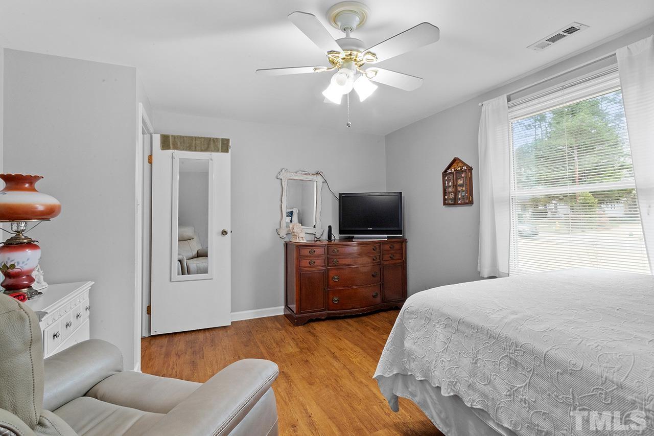 6921 Chamonix Place Raleigh, NC 27613 - Photo 16 of 30 a bedroom with a bed and a television