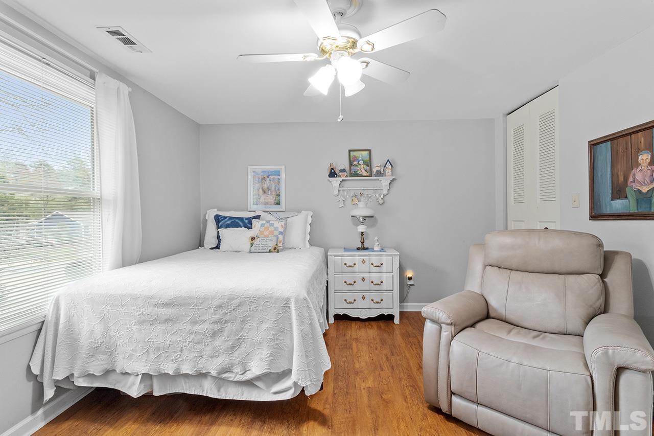 6921 Chamonix Place Raleigh, NC 27613 - Photo 17 of 30 a bedroom with a bed and wooden floor