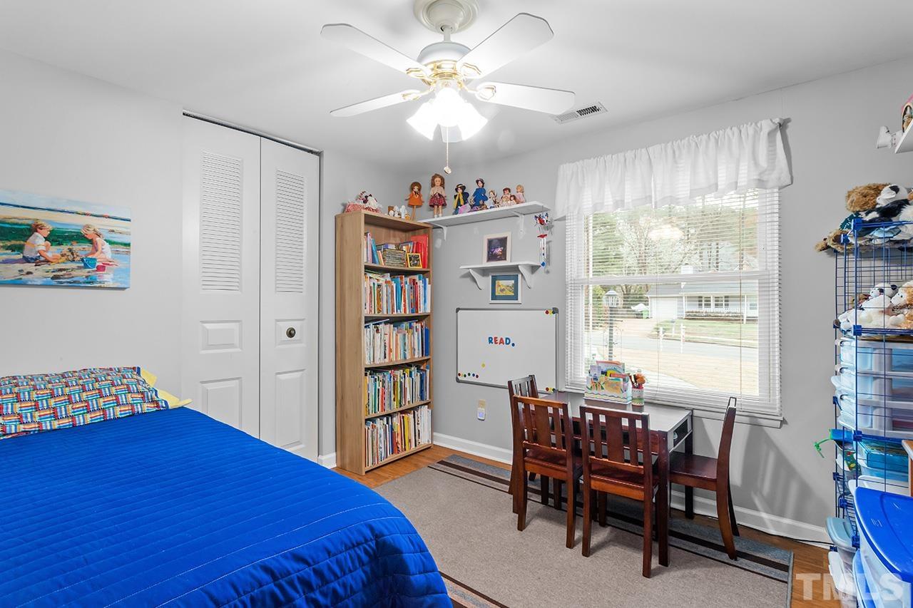 6921 Chamonix Place Raleigh, NC 27613 - Photo 18 of 30 a bedroom with a bed and a bookshelf