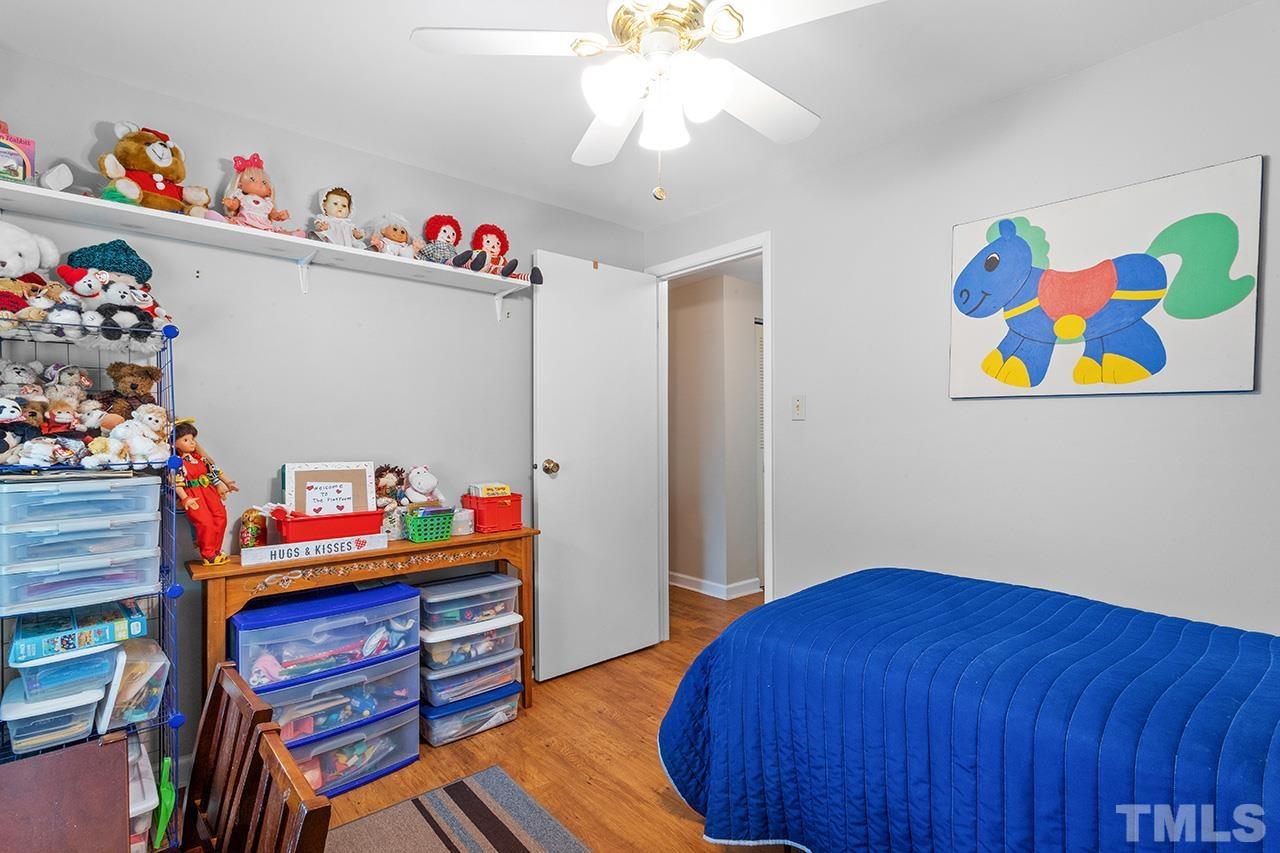 6921 Chamonix Place Raleigh, NC 27613 - Photo 19 of 30 a bedroom with a bed and wooden floor