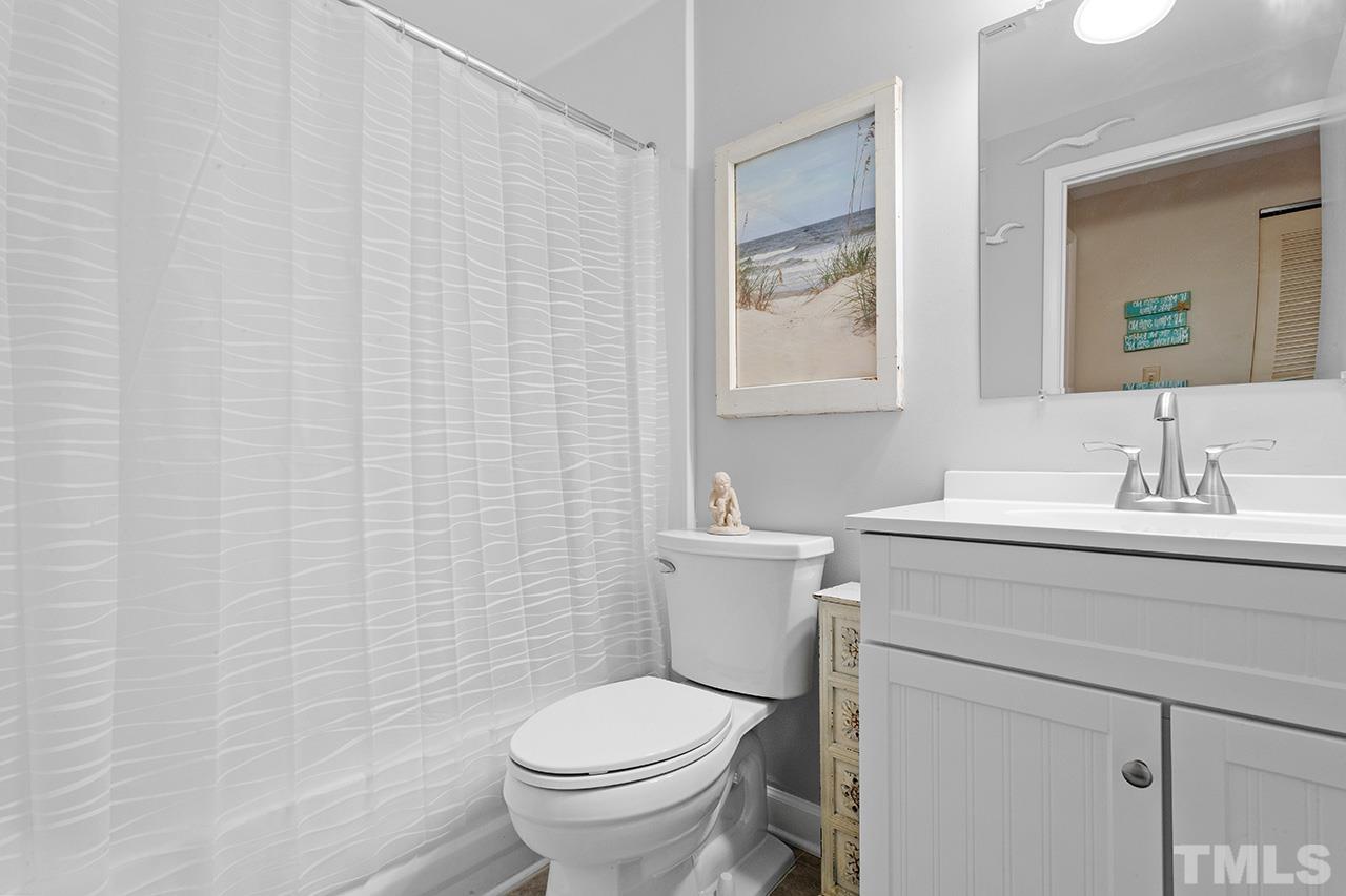 6921 Chamonix Place Raleigh, NC 27613 - Photo 20 of 30 a bathroom with a sink a toilet and a mirror