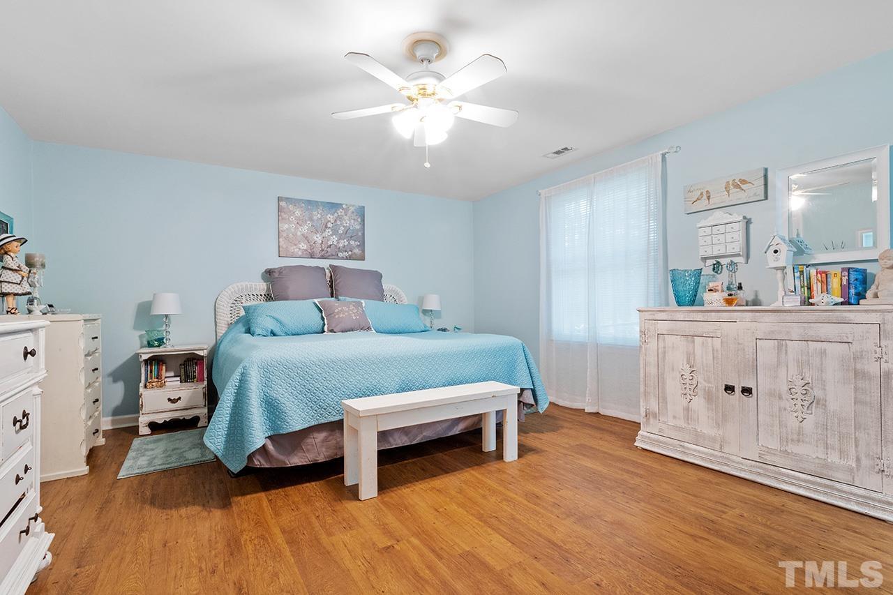 6921 Chamonix Place Raleigh, NC 27613 - Photo 21 of 30 a bedroom with a bed and a chandelier
