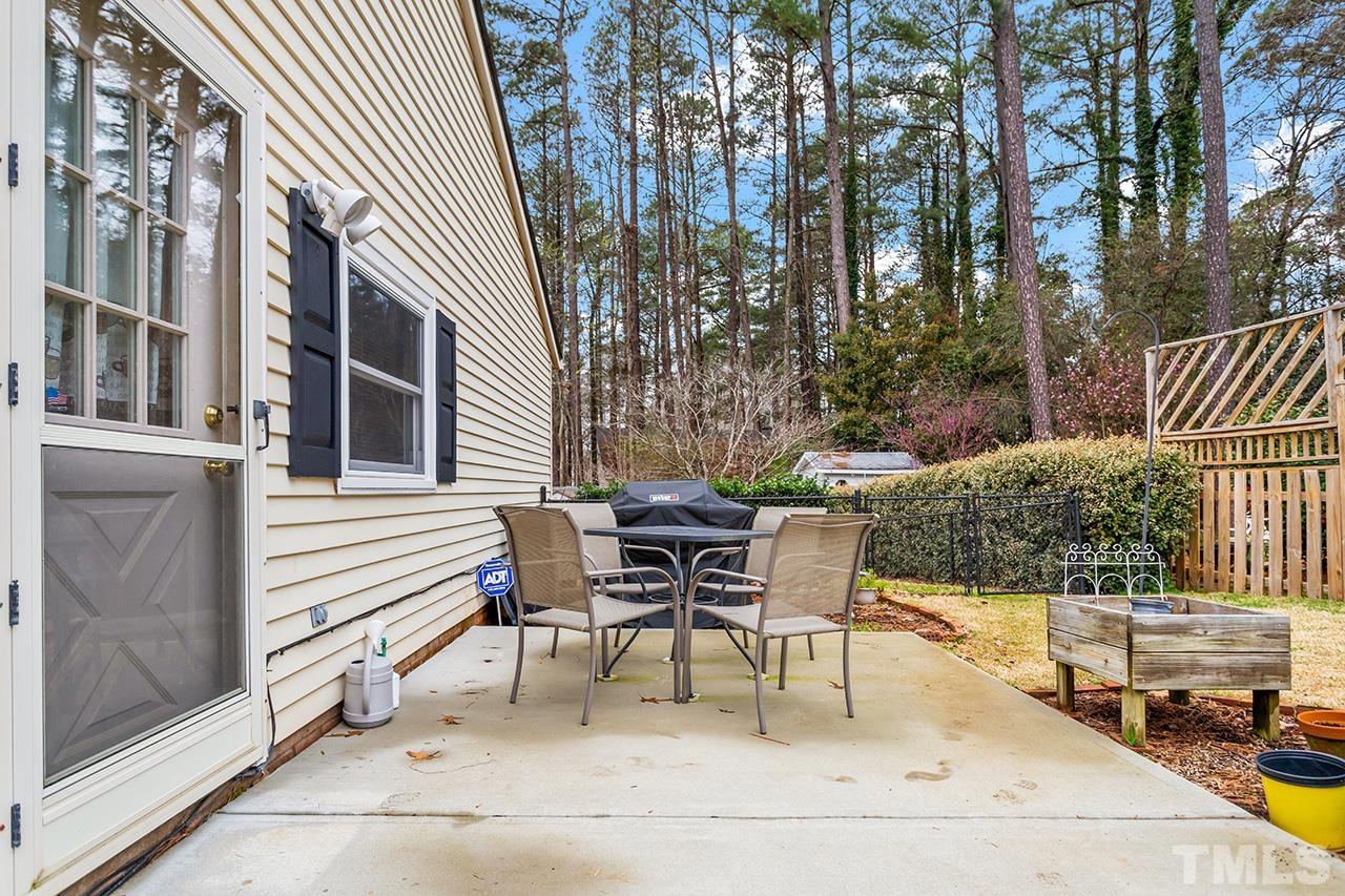 6921 Chamonix Place Raleigh, NC 27613 - Photo 25 of 30 a patio with table and chairs and potted plants