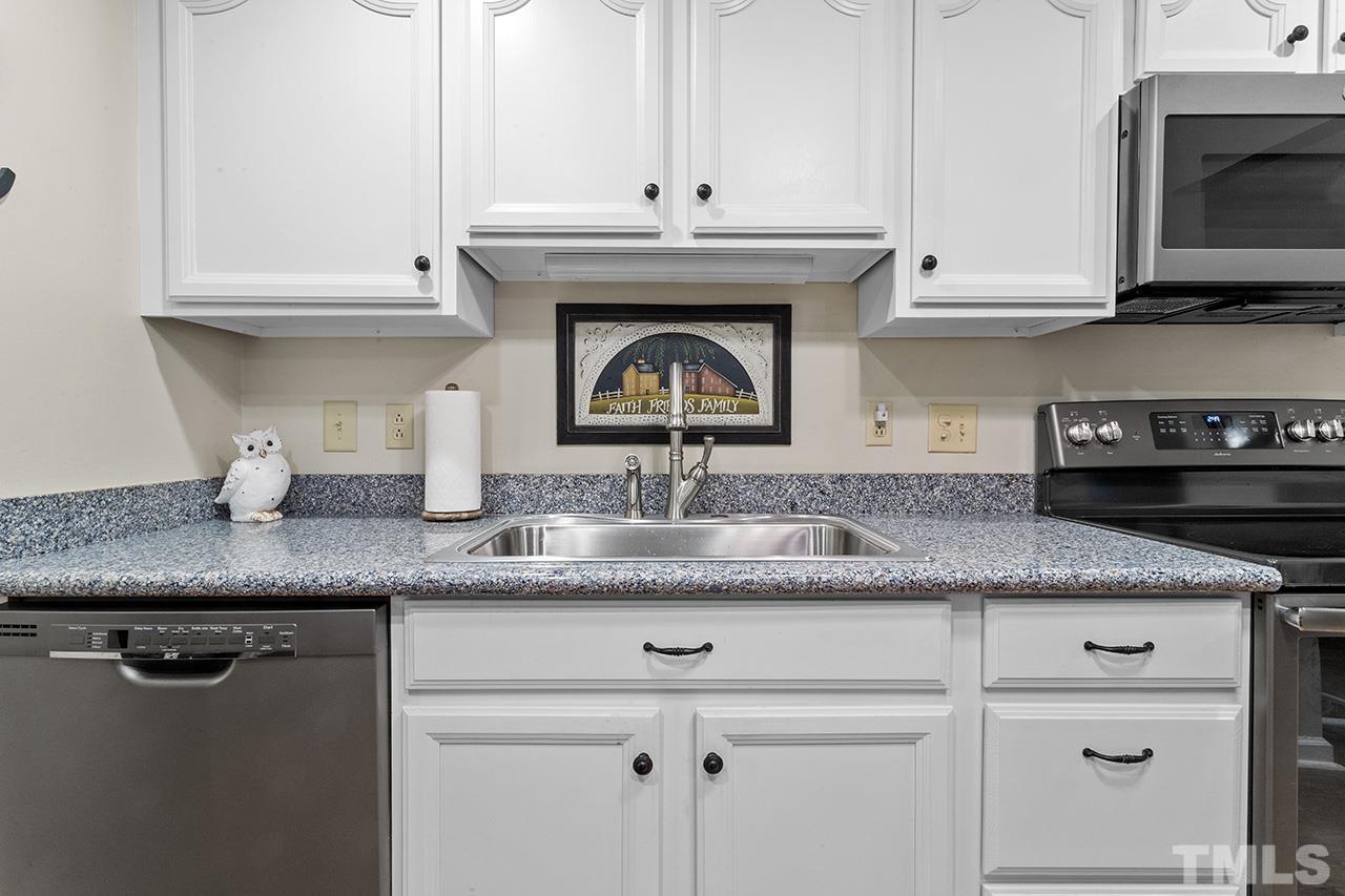 6921 Chamonix Place Raleigh, NC 27613 - Photo 4 of 30 a kitchen with granite countertop a sink a stove and cabinets
