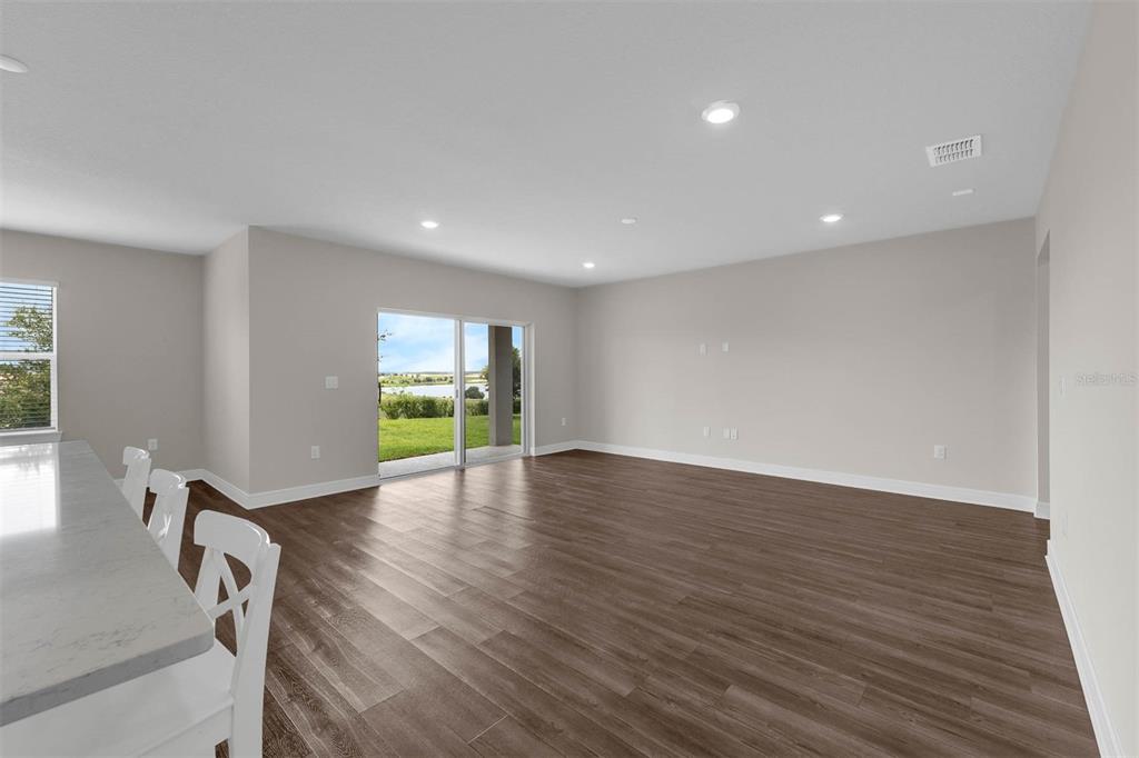 7367 Catania Loop Clermont, FL 34714 - Photo 12 of 58 a view of an empty room with wooden floor and a window
