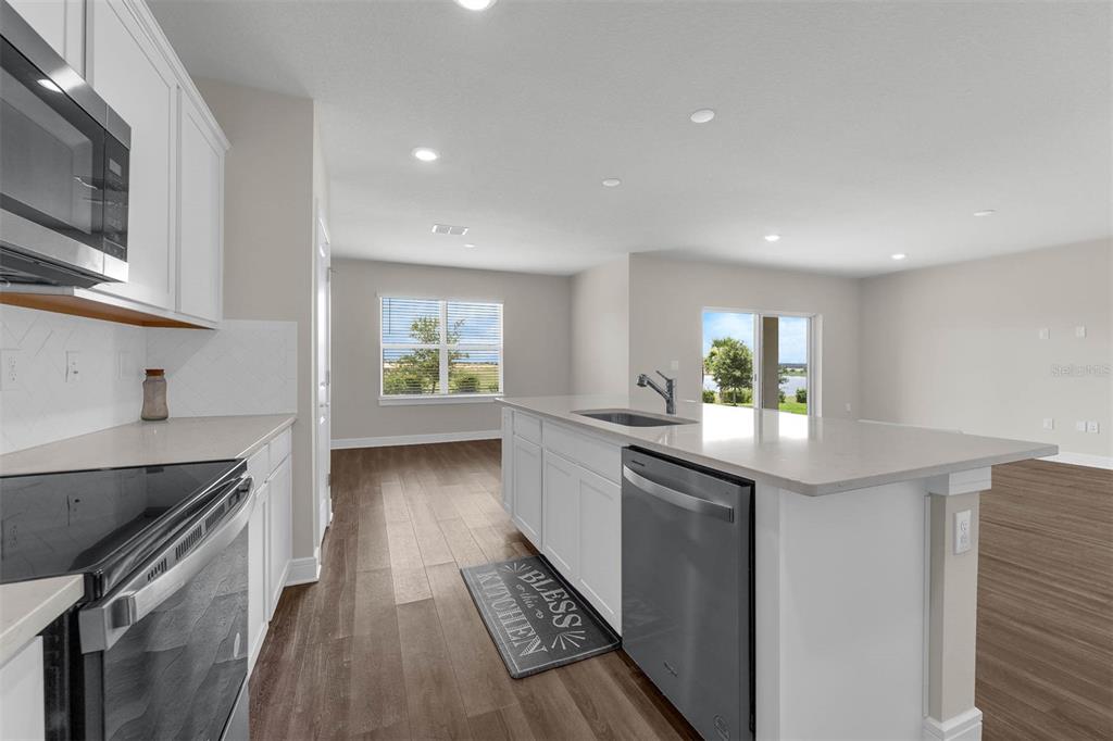 7367 Catania Loop Clermont, FL 34714 - Photo 2 of 58 a kitchen with granite countertop a sink stove and cabinets