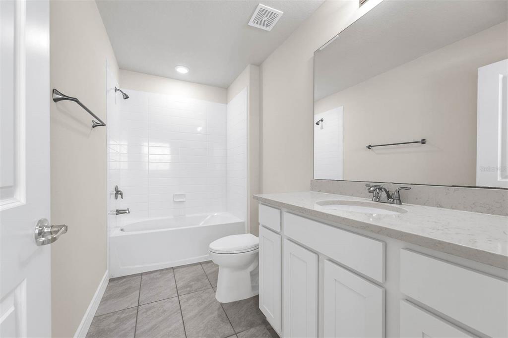7367 Catania Loop Clermont, FL 34714 - Photo 29 of 58 a bathroom with a granite countertop sink toilet mirror and bathtub
