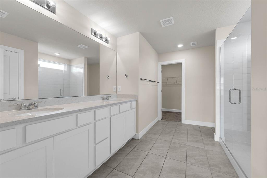 7367 Catania Loop Clermont, FL 34714 - Photo 35 of 58 a bathroom with a double vanity sink and a mirror