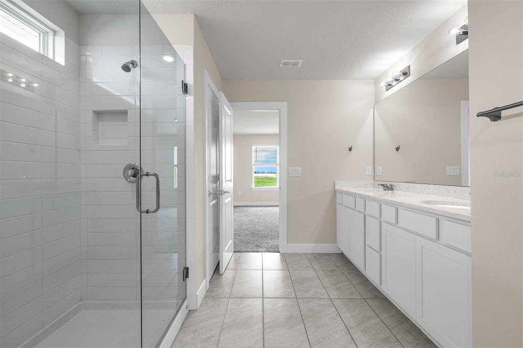 7367 Catania Loop Clermont, FL 34714 - Photo 38 of 58 a bathroom with a granite countertop sink mirror and shower