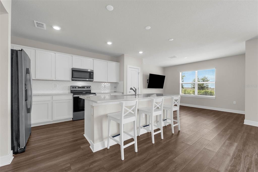 7367 Catania Loop Clermont, FL 34714 - Photo 6 of 58 a kitchen with microwave a refrigerator and chairs