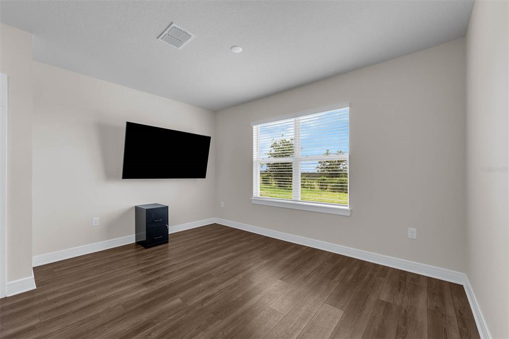 7367 Catania Loop Clermont, FL 34714 - Photo 10 of 58 a view of a livingroom with wooden floor and flat screen tv