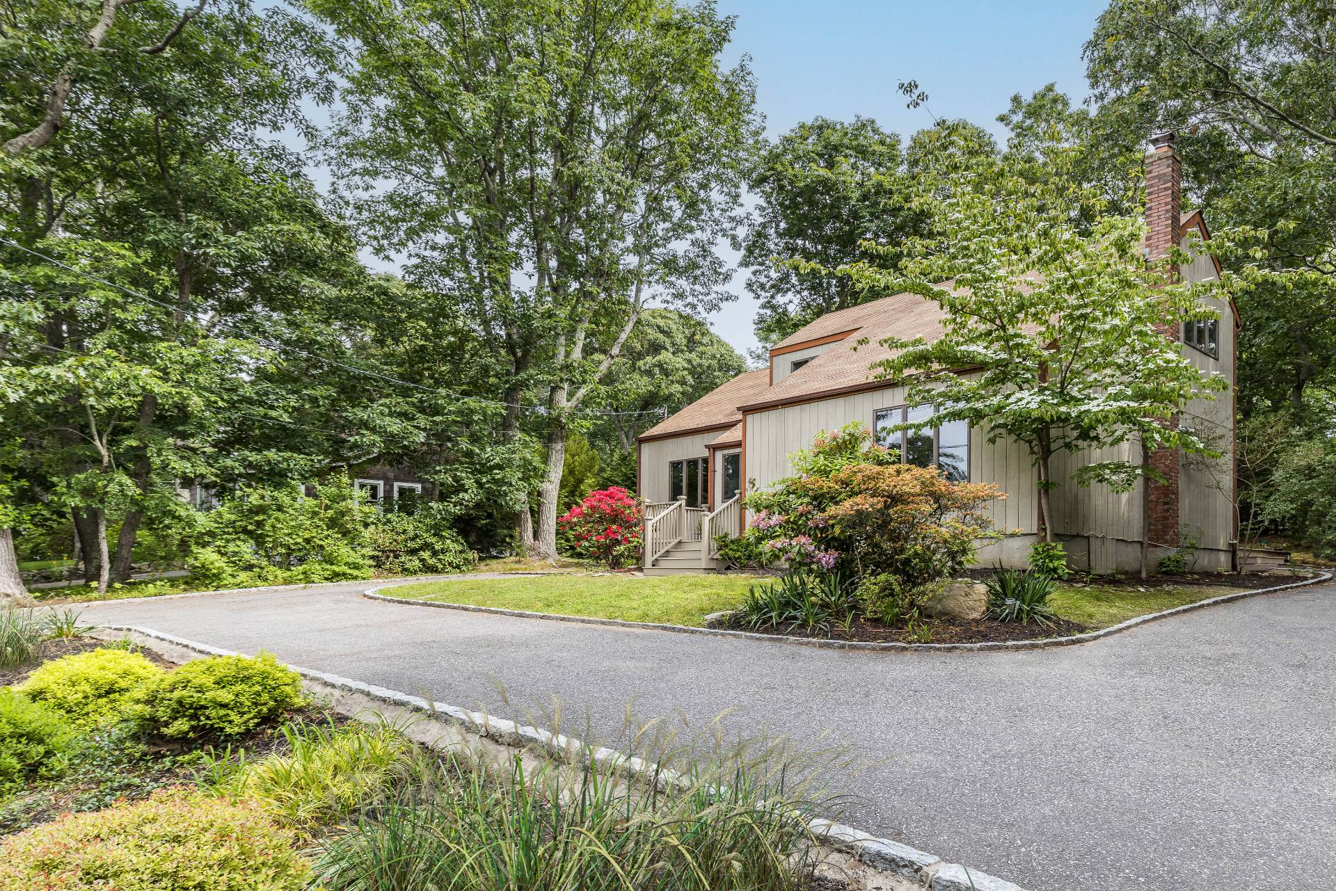 3564 Noyack Road Sag Harbor, NY 11963 - Photo 2 of 10 a front view of a house with a yard and a garage