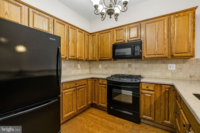 a kitchen with stainless steel appliances granite countertop a stove microwave and sink