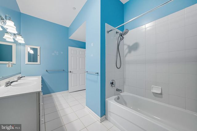 a bathroom with a tub a sink and a mirror