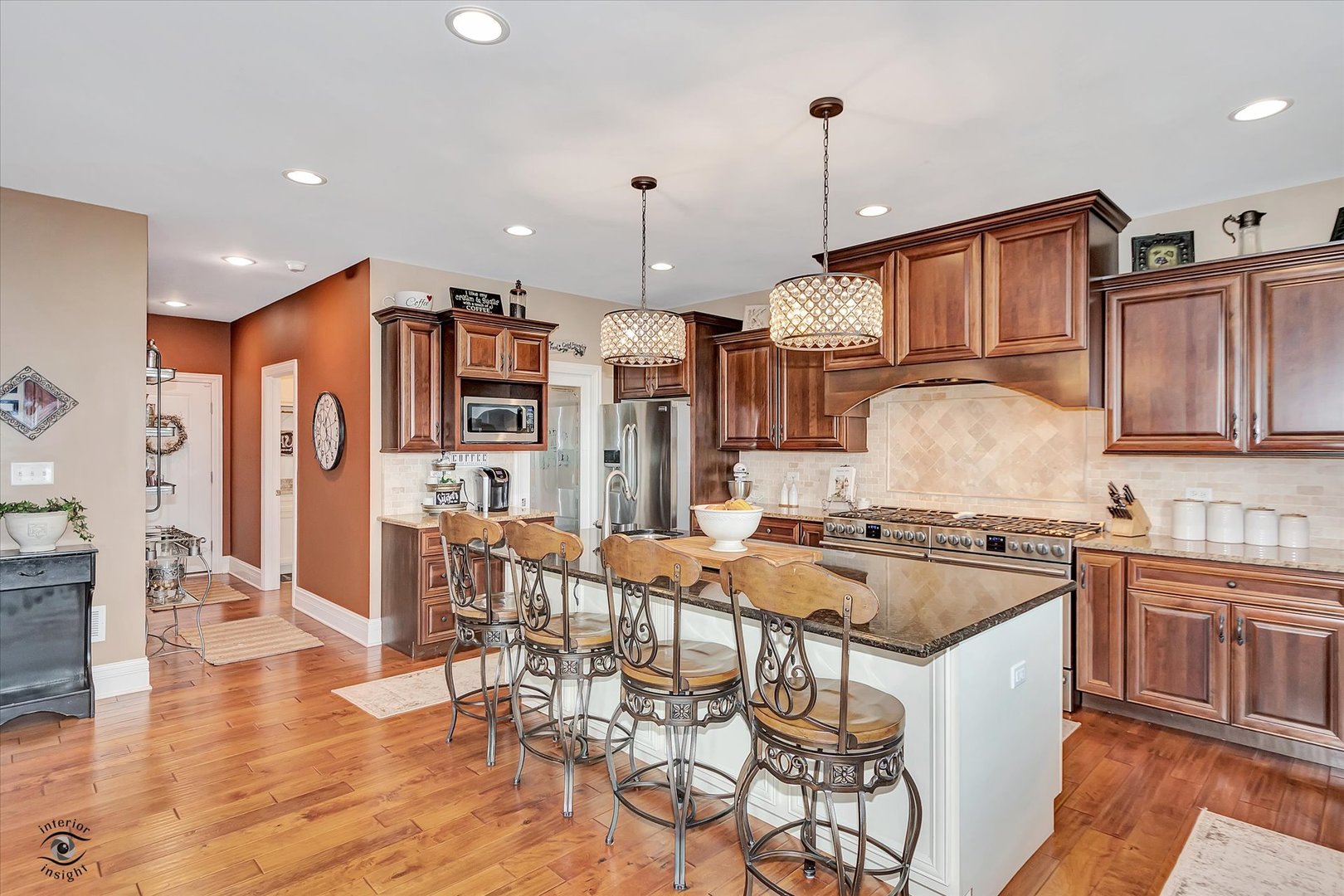 23933 Roberts Street Manhattan, IL 60442 - Photo 6 of 26 a kitchen with stainless steel appliances granite countertop a stove top oven a refrigerator a sink and a dining table with wooden floor