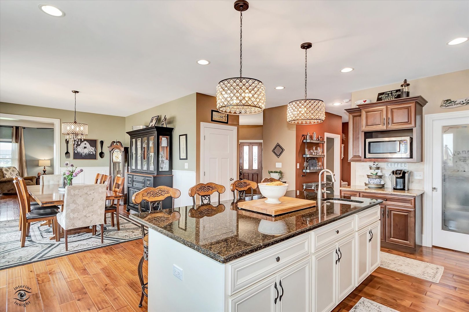 23933 Roberts Street Manhattan, IL 60442 - Photo 7 of 26 a kitchen with granite countertop a stove a sink a dining table and chairs