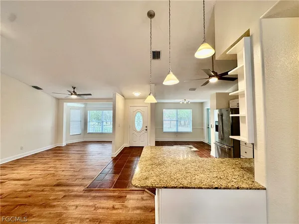 a view of a kitchen with granite countertop a sink and a wooden floor