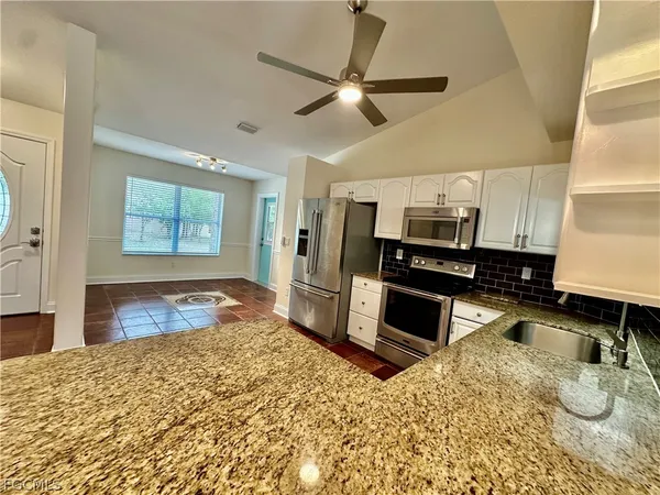 an empty room with wooden floor and ceiling fan