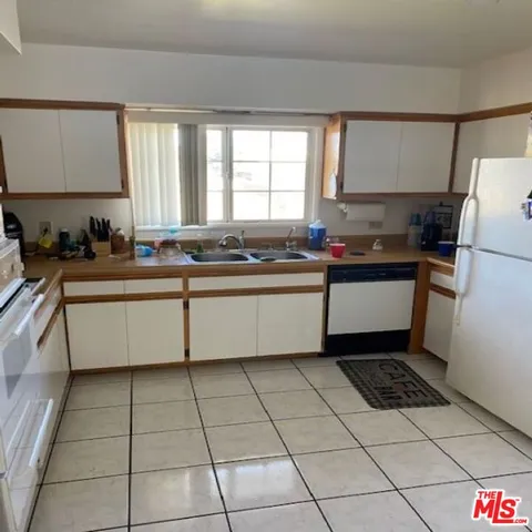 a kitchen with a sink a stove a refrigerator and cabinets
