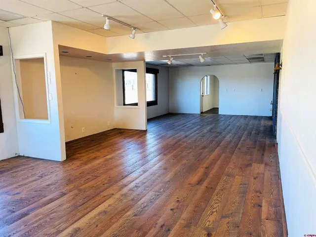 a view of empty room with wooden floor and fireplace