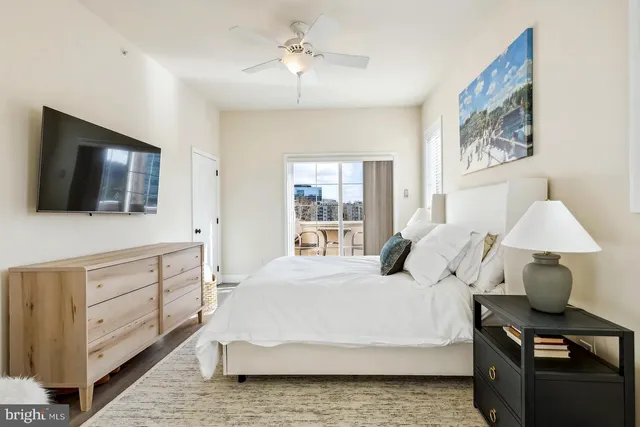 a bedroom with a large bed and a flat tv screen on dresser