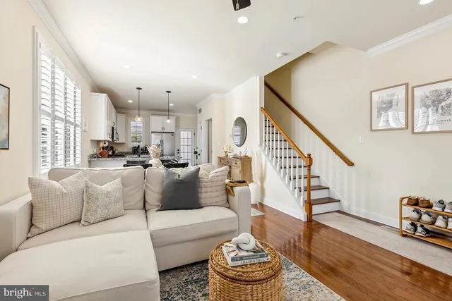 a living room with furniture and a dining table with wooden floor