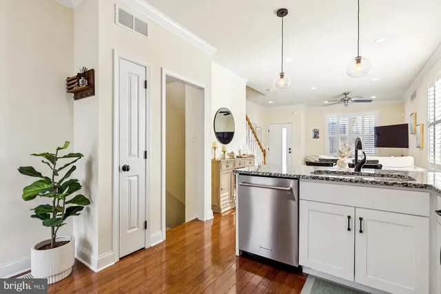 a kitchen with stainless steel appliances a counter space a sink a refrigerator and a window