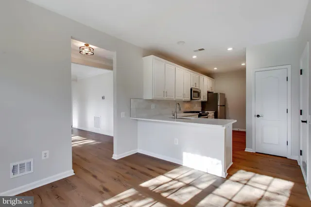 a kitchen with stainless steel appliances granite countertop a refrigerator and a stove top oven
