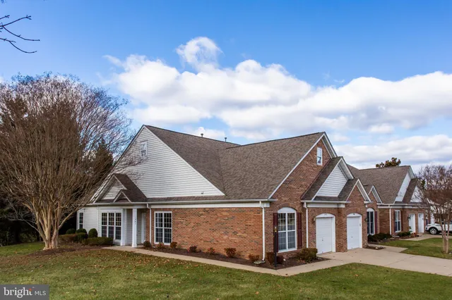a view of a big house with a big yard and large trees