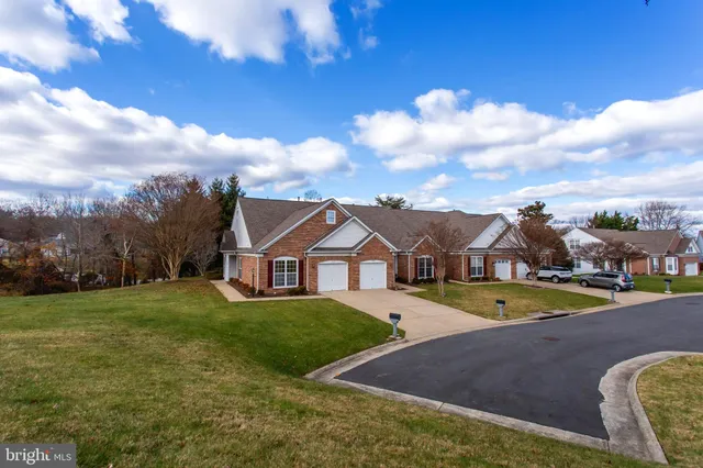 a view of a white house with a big yard and large tree