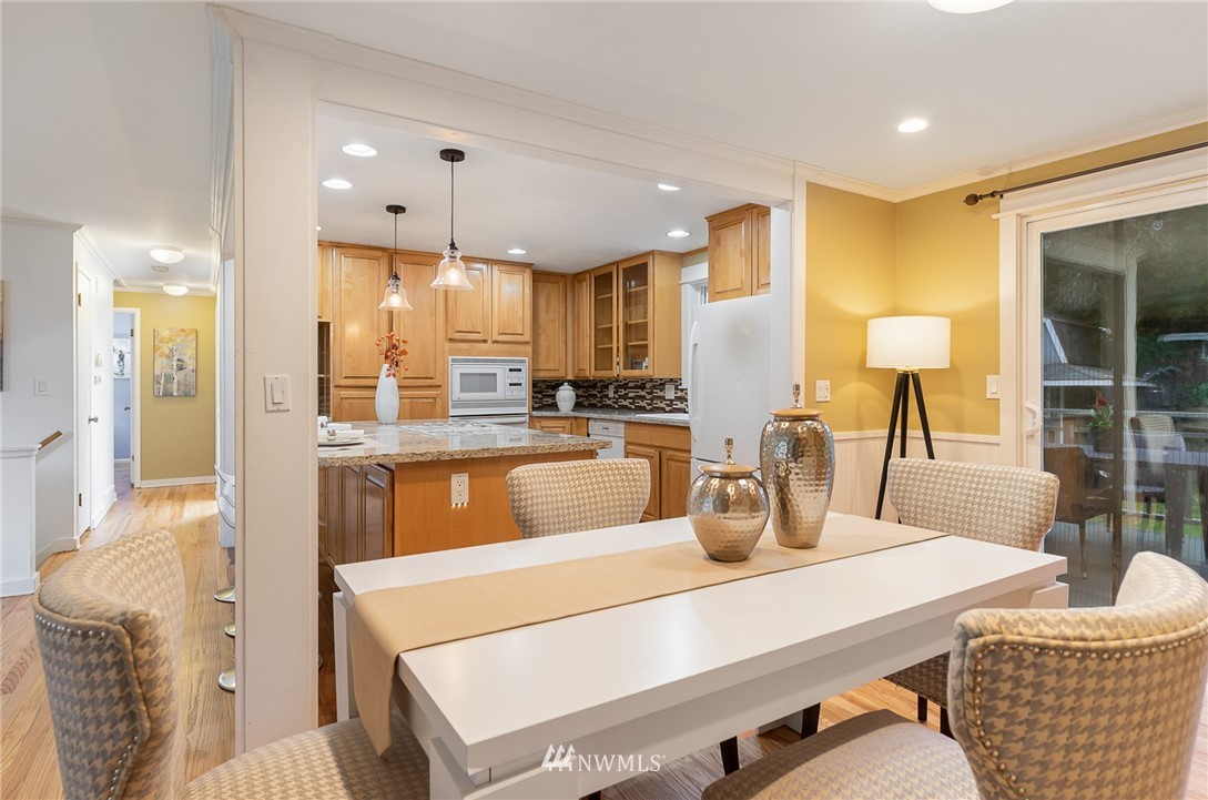 9215 Northeast 183rd Street Bothell, WA 98011 - Photo 6 of 38 a kitchen with stainless steel appliances kitchen island granite countertop a table chairs and a refrigerator