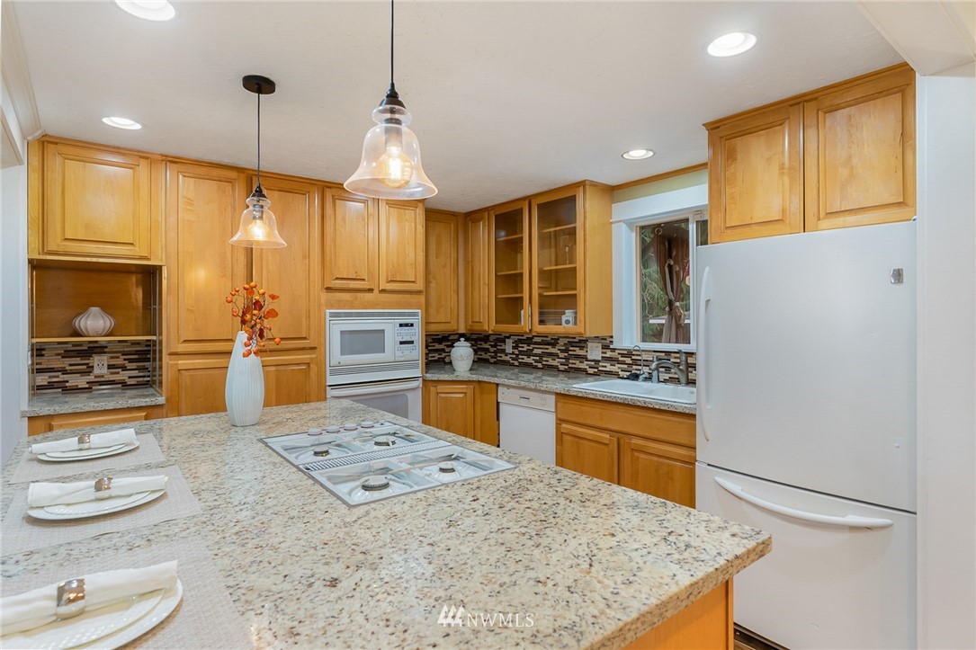 9215 Northeast 183rd Street Bothell, WA 98011 - Photo 7 of 38 a kitchen with kitchen island a stove a sink and a refrigerator