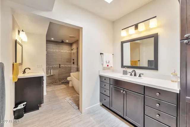 a bathroom with a double vanity sink mirror and toilet