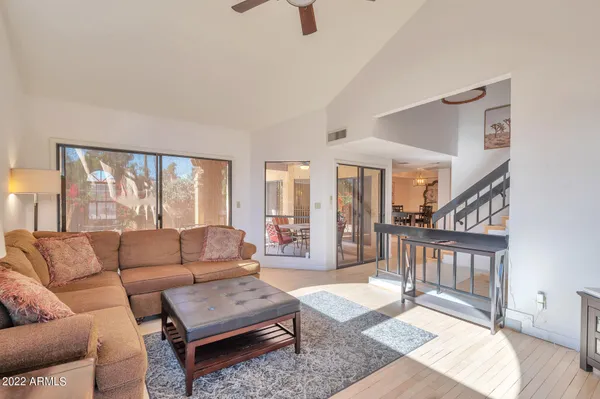 a living room with furniture a wooden floor and a large window