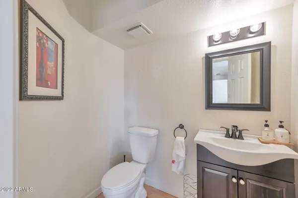 a bathroom with a sink vanity mirror and toilet