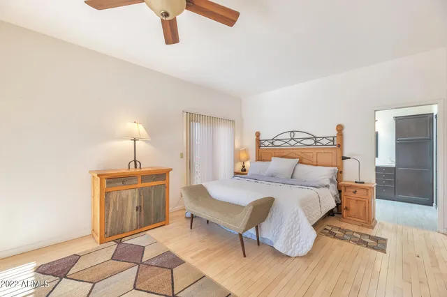 a bedroom with a bed and wooden floor