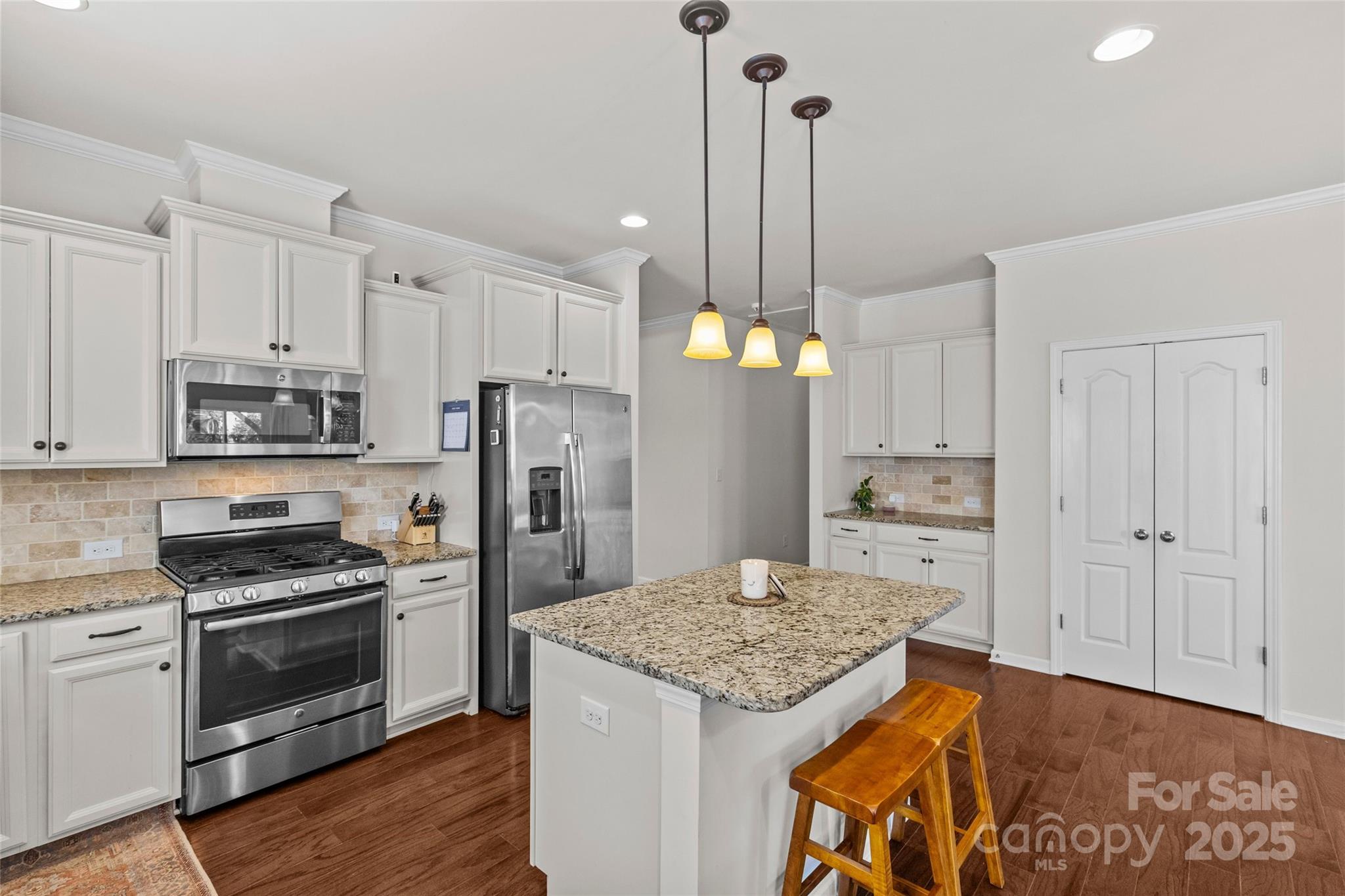 5828 Eleanor Rigby Road Charlotte, NC 28278 - Photo 9 of 39 a kitchen with stainless steel appliances kitchen island granite countertop a refrigerator a stove and white cabinets with wooden floor