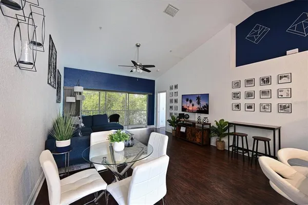 a dining room with furniture a chandelier and wooden floor